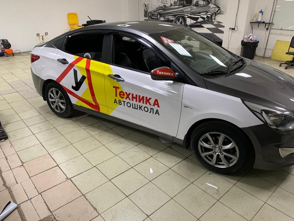 Аппликация автошколы на боковых дверях легкового автомобиля