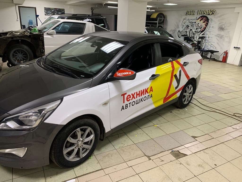 Брендирование легкового автомобиля автошколы, вид сбоку
